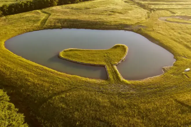 a peninsula in a large pond built by Bulletproof Pond and Lake - does a pond increase property value - pond peninsula and island benefits