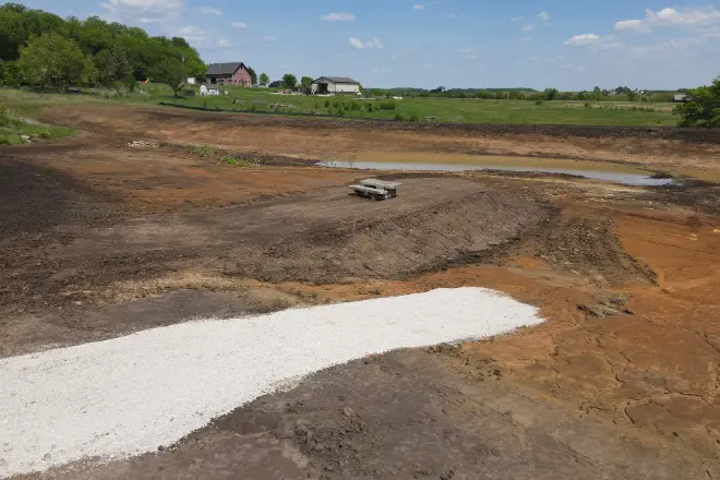 A peninsula and boat ramp under construction for an acreage pond