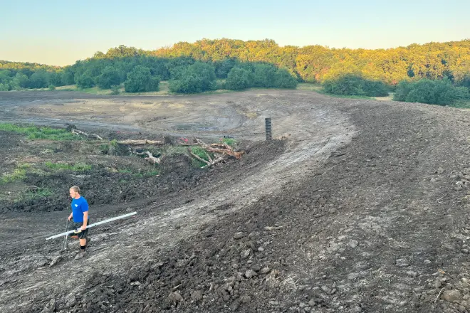 A pond installation expert surveys the landscape