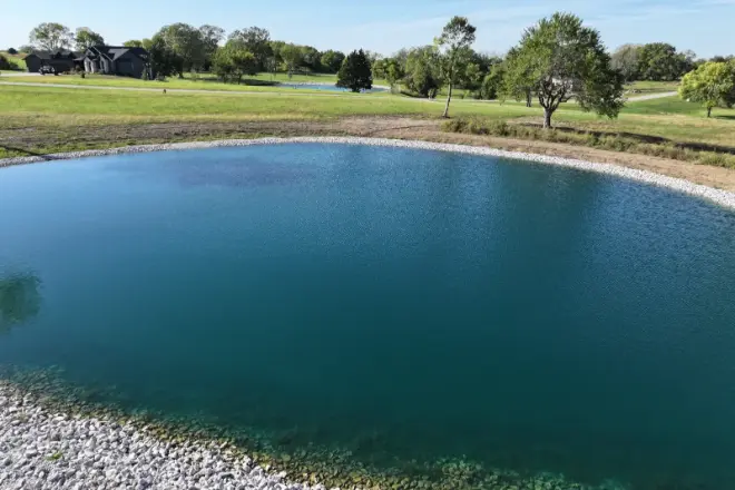 A pond with landscaping by Bulletproof Pond and Lake