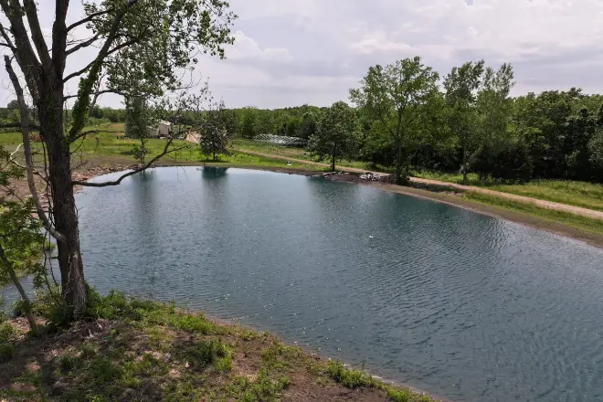 A completed pond project after it has filled with rainwater. what is a swale