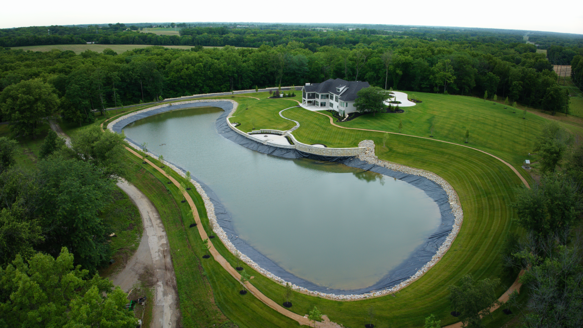 Luxury Waterfront Estate Lined Pond, Lined with Rip-rap rock, upscale landscaping, in Liberty Missouri Completed by Bulletproof Pond and Lake. Home Built by Starr Homes
