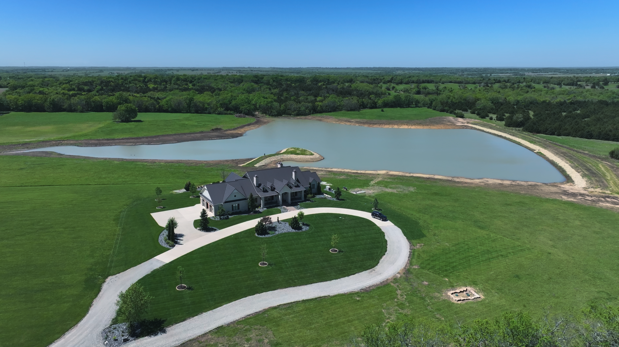 12 Acre New Lake Construction with rip-rap lined peninsula, natural fish structure rock lined lake, expansion in Melvern Kansas. Designed and built by Bulletproof Pond and Lake