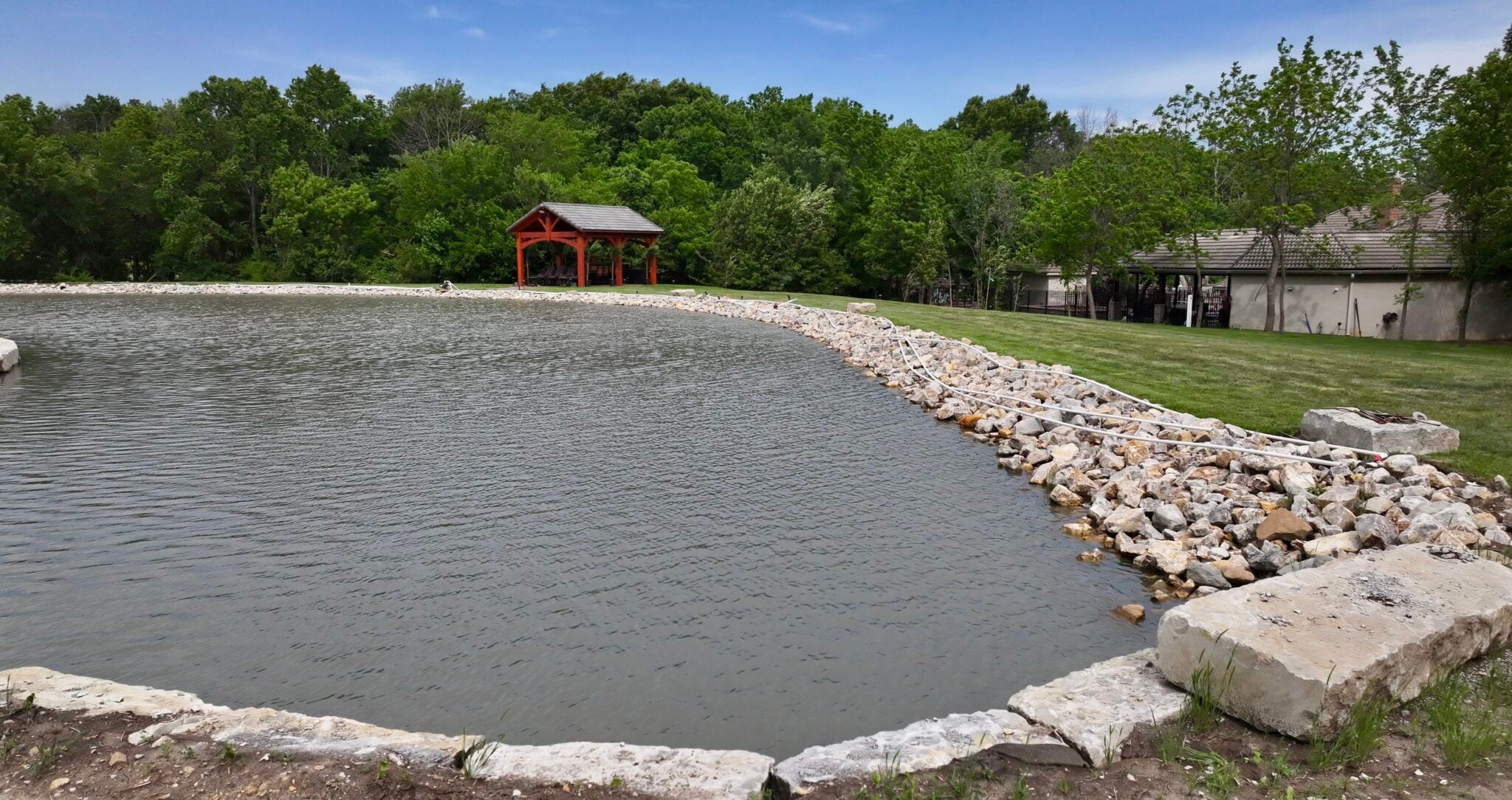 Limestone edging and riprap shoreline around a large pond and peninsula on an upscale property near Kansas City, Missouri