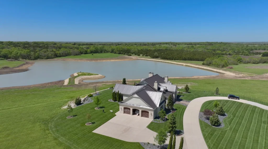 Estate home overlooking a 12-acre lake expansion with a limestone-edged peninsula, built by Bulletproof Pond and Lake in Melvern, Kansas