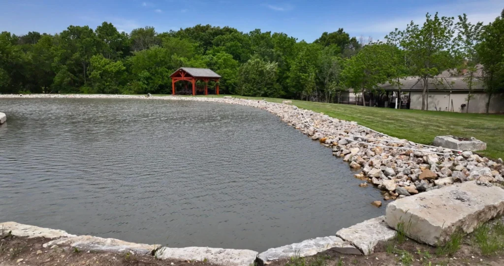 Limestone edging and riprap shoreline around a large pond and peninsula on an upscale property near Kansas City, Missouri